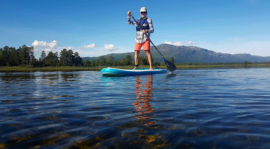 Kvinna paddlar på sjö med SUP